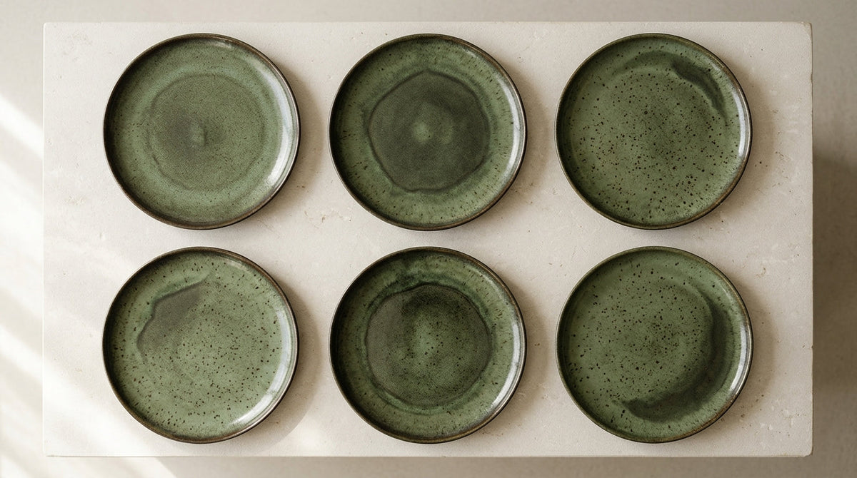 Six Arco dinner plates from one firing, laid out to show the range of the glaze.