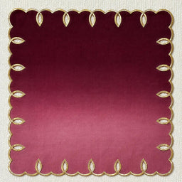 Foglia embroidered linen napkin in Burgundy, flat on a neutral backdrop