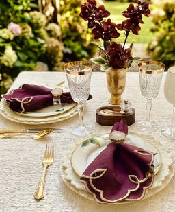 Foglia embroidered napkins on a garden dinner table with crystal and gold cutlery